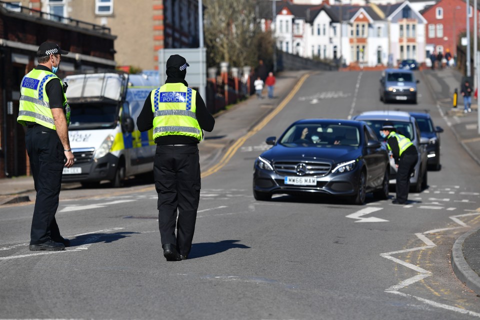 Police stop motorists on roads leading to the beach at Barry island in South Wales to check if their journeys are essential