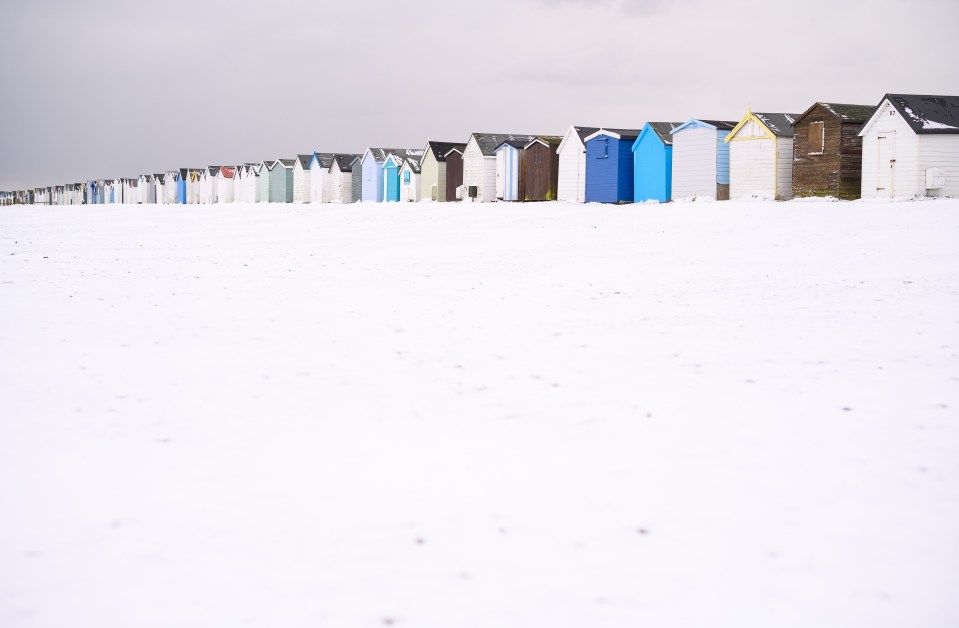 Snow covers a row of multi-coloured beach huts in Southend