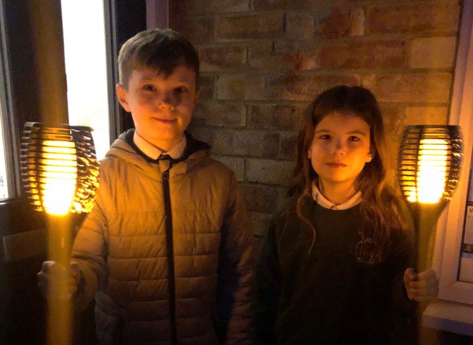 Blake, 11, and Dorrie Cunningham, 8, held torches in Bookham, Surrey to remember those passed during the last year