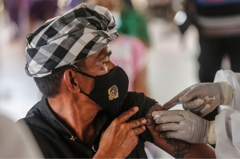 A man in Bali gets a dose of the Chinese-made CoronaVac