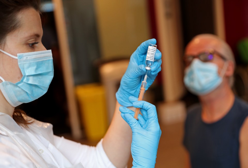 The Covid vaccine appears to ease symptoms of long Covid. Pictured: Ellie Morton prepares a dose of the AstraZeneca jab at Kingston University's Penrhyn Road campus, London, on March 12