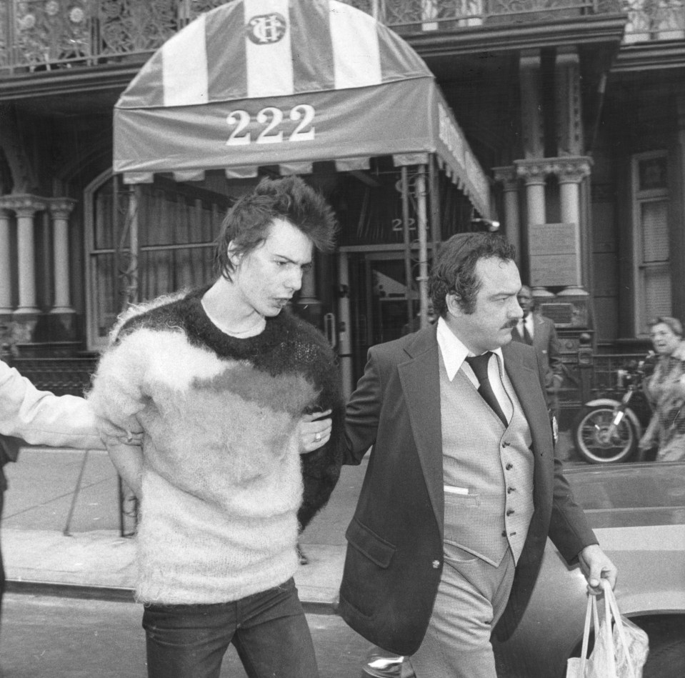 Sid is led away from the Chelsea hotel after the murder