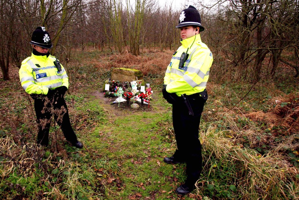 Police officers stand near tributes left for Paula Clennell at Levington near Ipswich