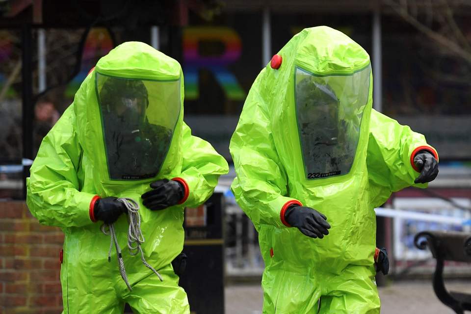 Members of the emergency services wear green biohazard encapsulated suits as they work to cover the bench where ex Russian spy Sergei Skripal and his daughter Yulia were found on March 4, 2018