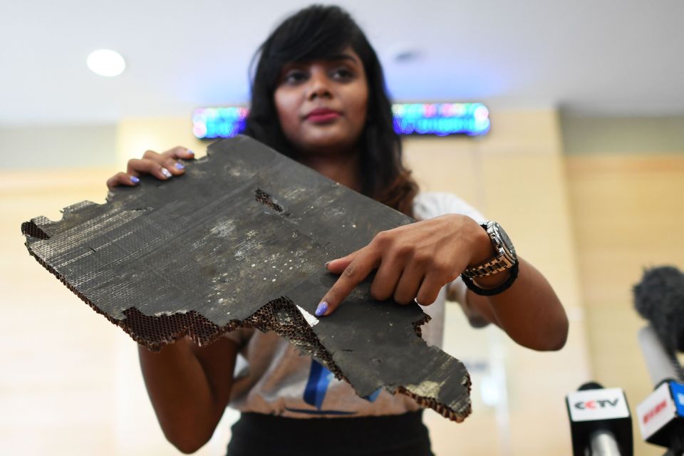 Grace Subathirai Nathan, who mother Anne Daisy was on MH370, hold a piece of wreckage in 2018