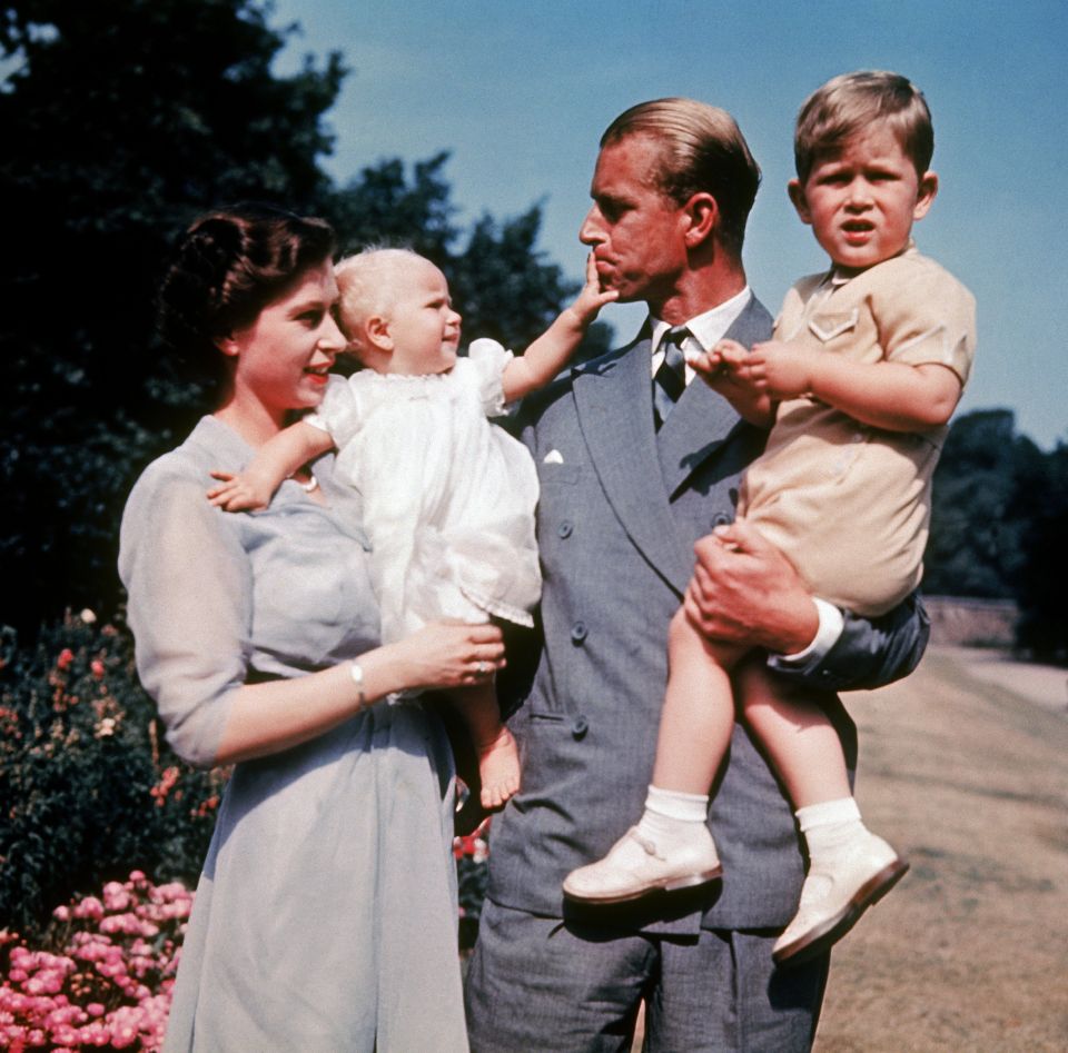 The Queen is seen holding Princess Anne while Prince Philip holds Prince Charles in a photo taken in 1951