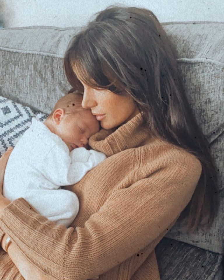 A mother cuddling her newborn baby.