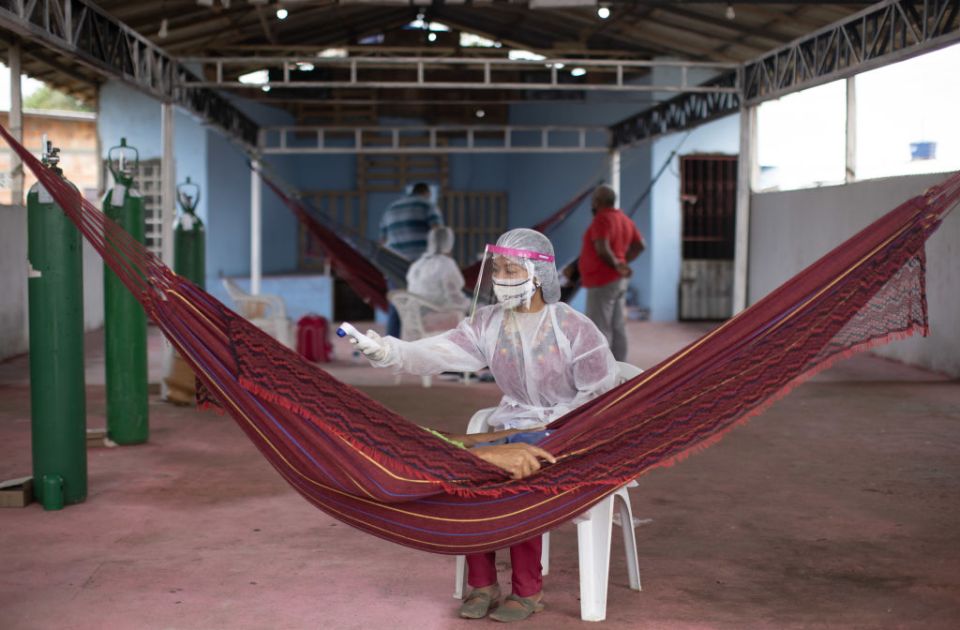 A nurse takes the temperature of a Covid-19 patient member of the Witoto indigenous tribe at a hospital set up near Manaus, Brazil