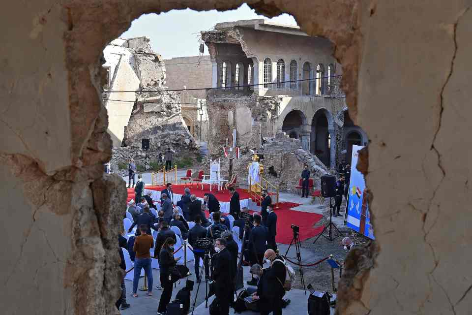 Iraqis gather in the ruins of the Syriac Catholic Church of the Immaculate Conception