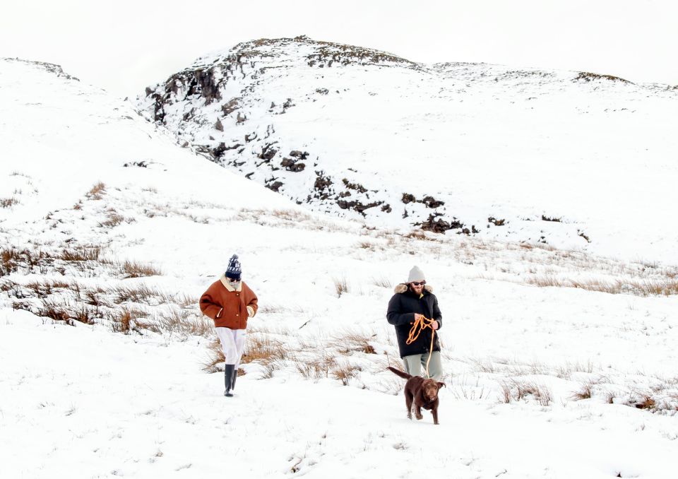 A couple walks their dog in the Yorkshire Dales National Park after a fresh snowfall at the weekend