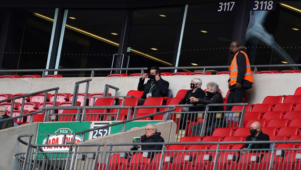 Salford co-owner Gary Neville adjusts his face mask amid the action