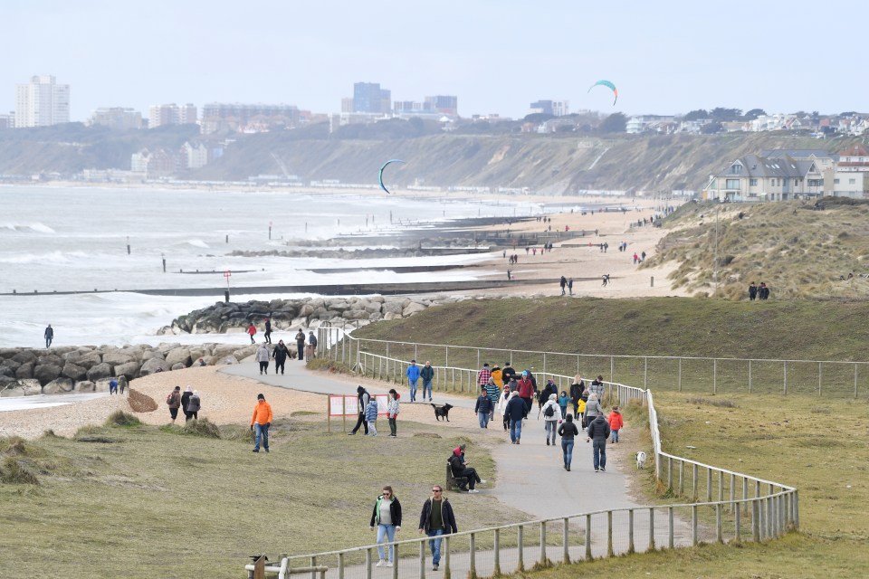 Walkers enjoy the spring weather at Hengistbury Head in Dorset before temperatures turn colder