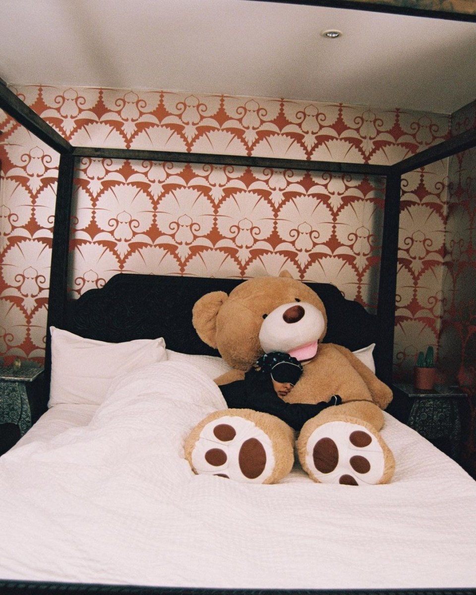 The star cosied up to a huge teddy bear in her four poster bed