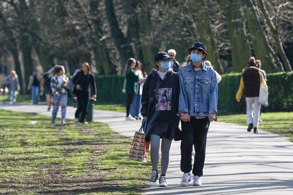 Members of the public wearing face masks walk through Hyde Park, Leeds