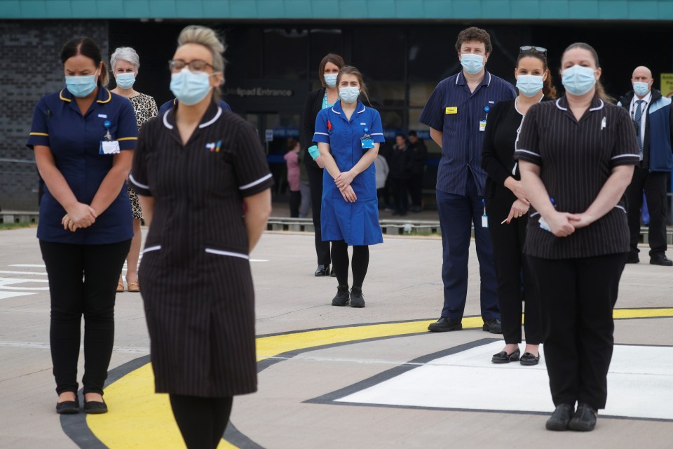 Hospital staff observe a minute's silence outside the Aintree University Hospital in Liverpool