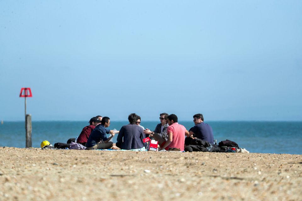 People sit on Bournemouth beach following the easing of England's lockdown