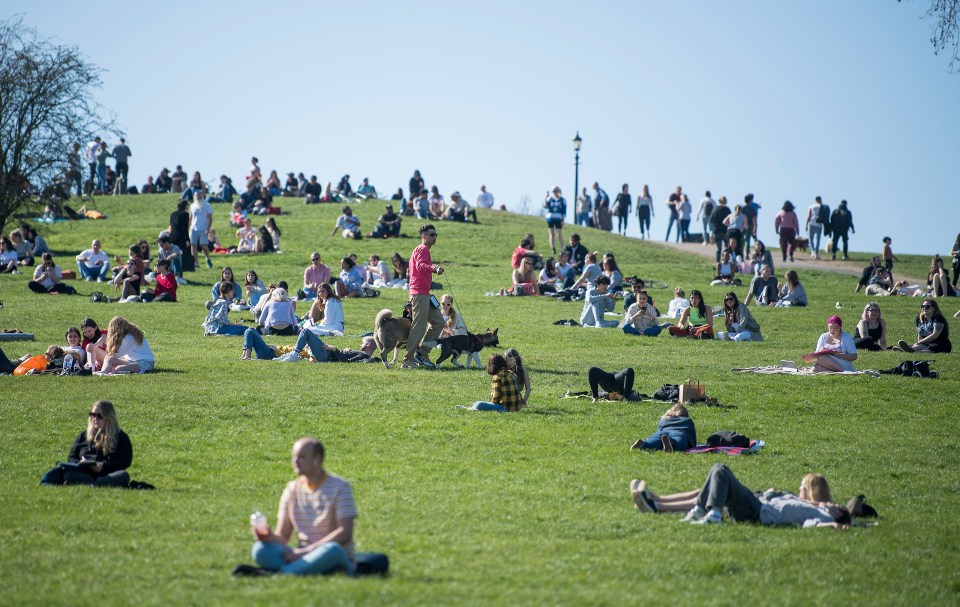 Members of the public relax in the warm weather on Primrose Hill in North London