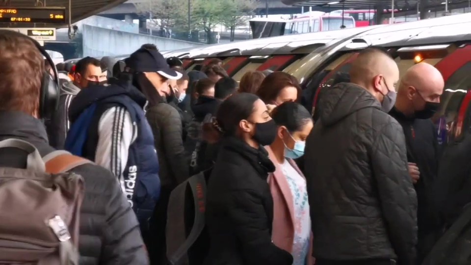 Workers packed onto Tubes at Canning Town station in London this morning