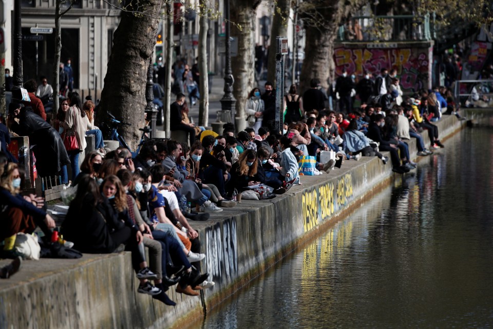 People enjoy a sunny spring day along the banks of the canal Saint-Martin, as country enters a third national lockdown in Paris, France, April 4, 2021