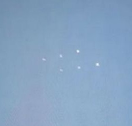 Six white dots were spotted appearing to hover in the sky