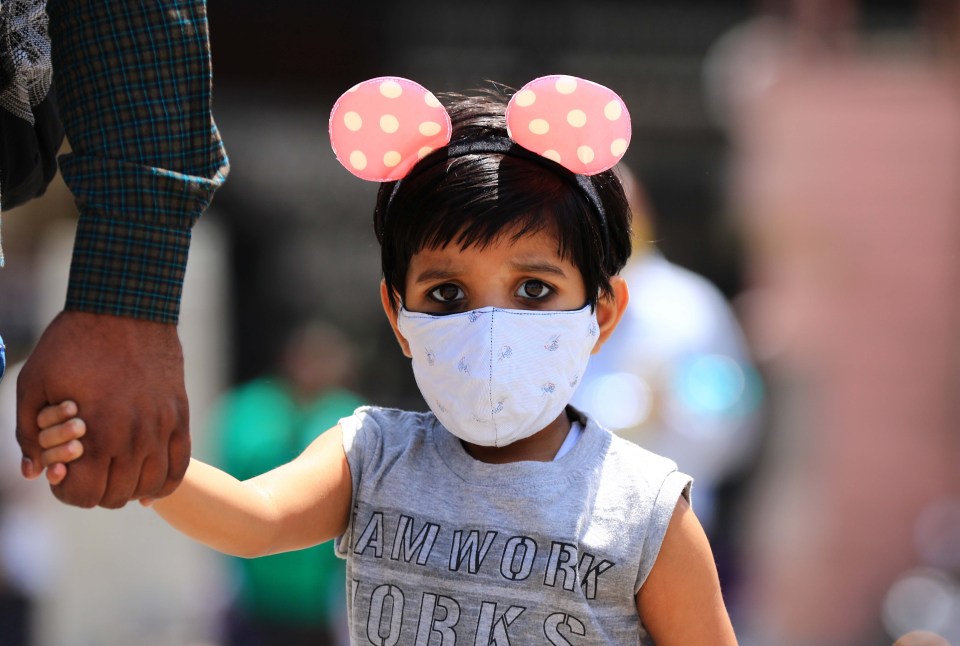 A young girl arrives to board a bus after the Rajasthan Government imposed lockdown measures