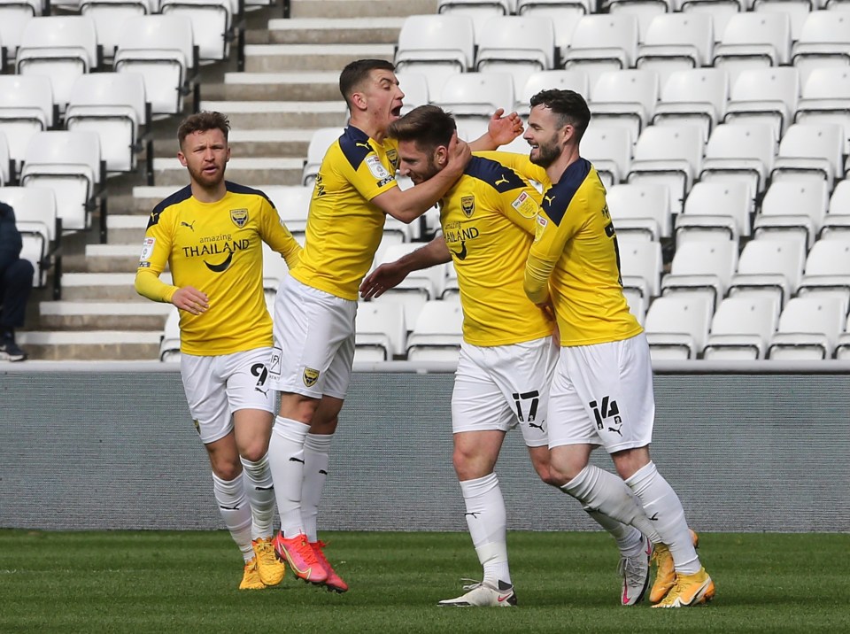 James Henry is mobbed by his team-mates after firing Oxford ahead