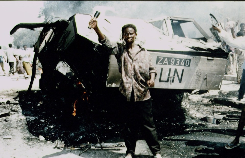 A Somali stand near the wreckage of an American armoured personnel carrier in Mogadishu in 1993