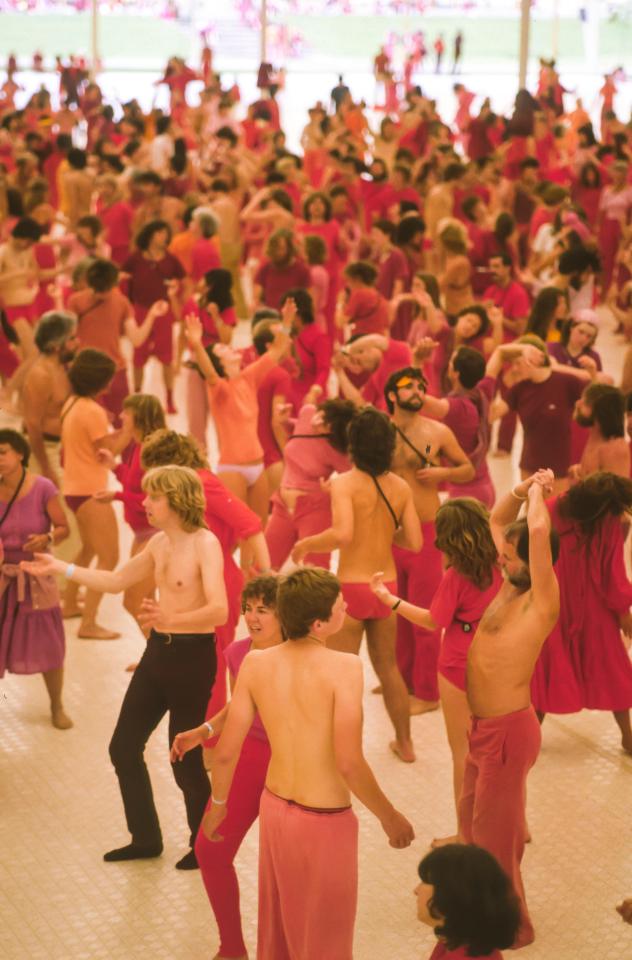 Followers dance as a mass meeting at the Rajneeshpuram