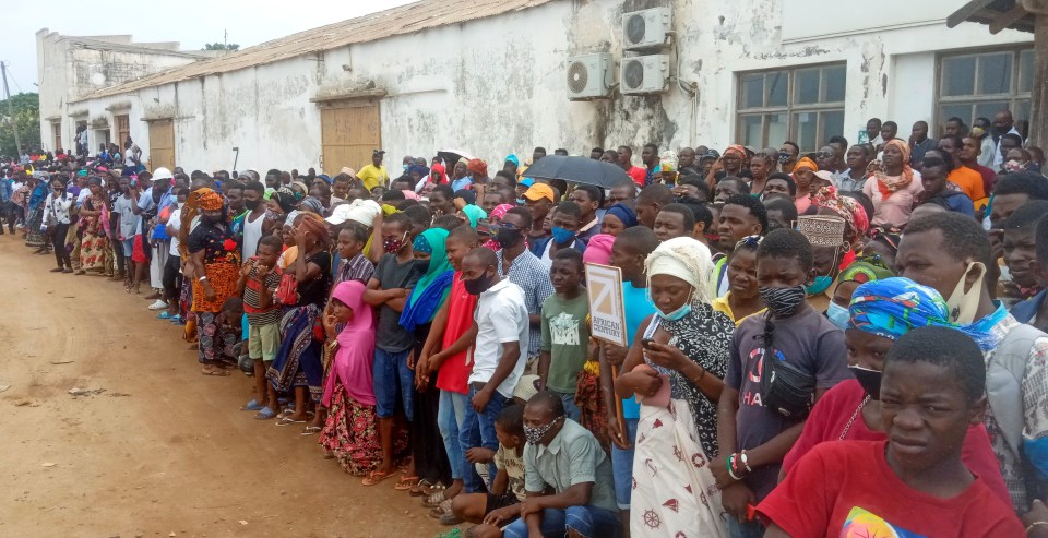 People wait for friends and relatives as a ship carrying people fleeing arrives in Pemba