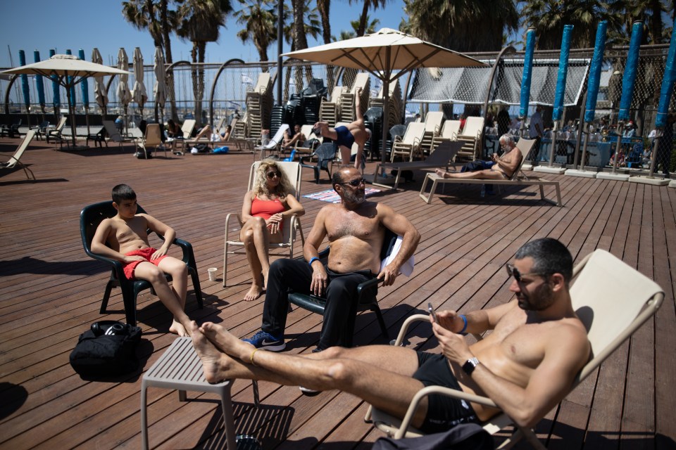 Peopel relax at Gordon Pool in Tel Aviv, which only allows holders of the green passport to enter