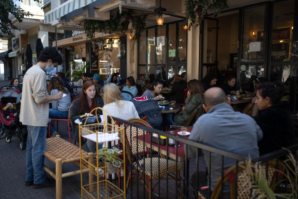 Israelis sit in a café in Tel Aviv - only those who are jabbed can go to the venue