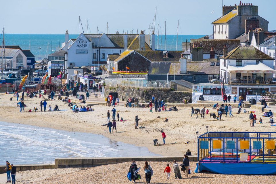 The beach in Lyme Regis, Dorset, busy in spite of the chilly breeze