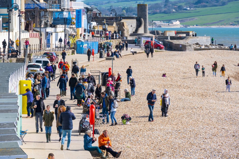 Families flock to the picturesque beach at the seaside resort of Lyme Regis on Good Friday