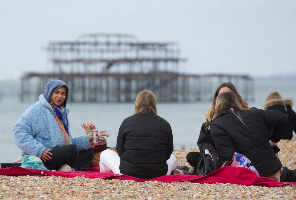 Groups sat on the pebbles on the south coast to enjoy the last of the mild weather