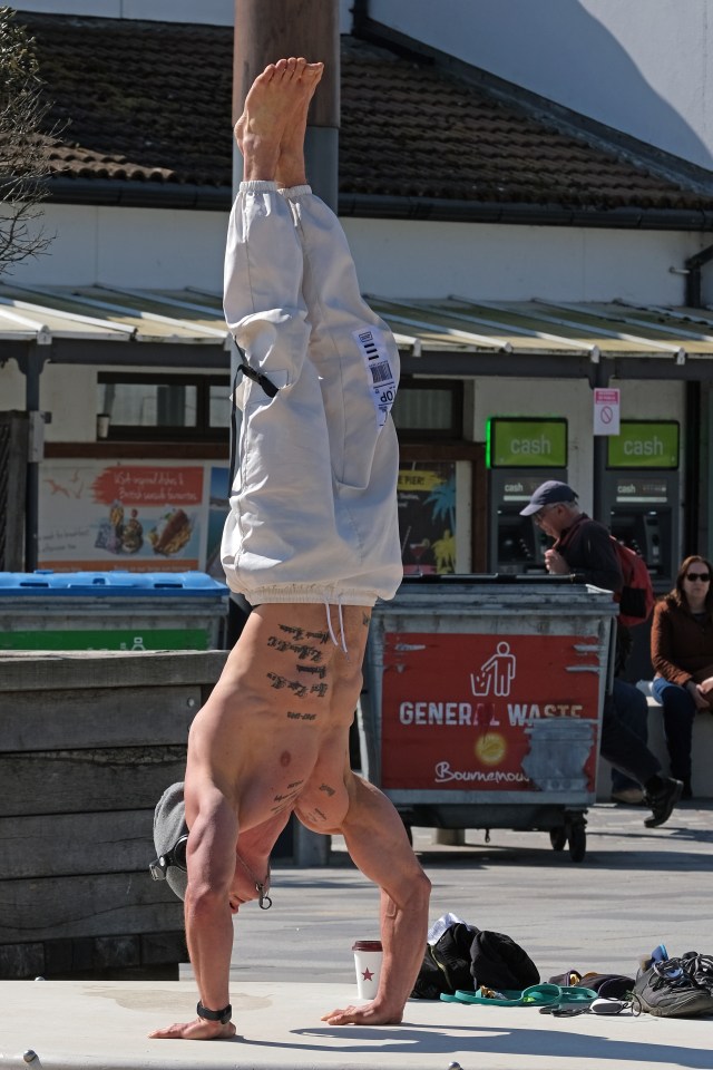 A man does a handstand in the sunshine in Bournemouth