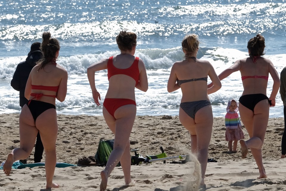 People on the sand in Bournemouth head for the water