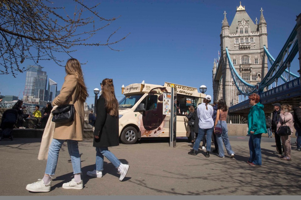 Sightseers enjoying an ice-cream at Tower Bridge in London