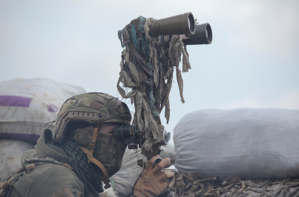 Another Ukrainian soldier looking through binoculars