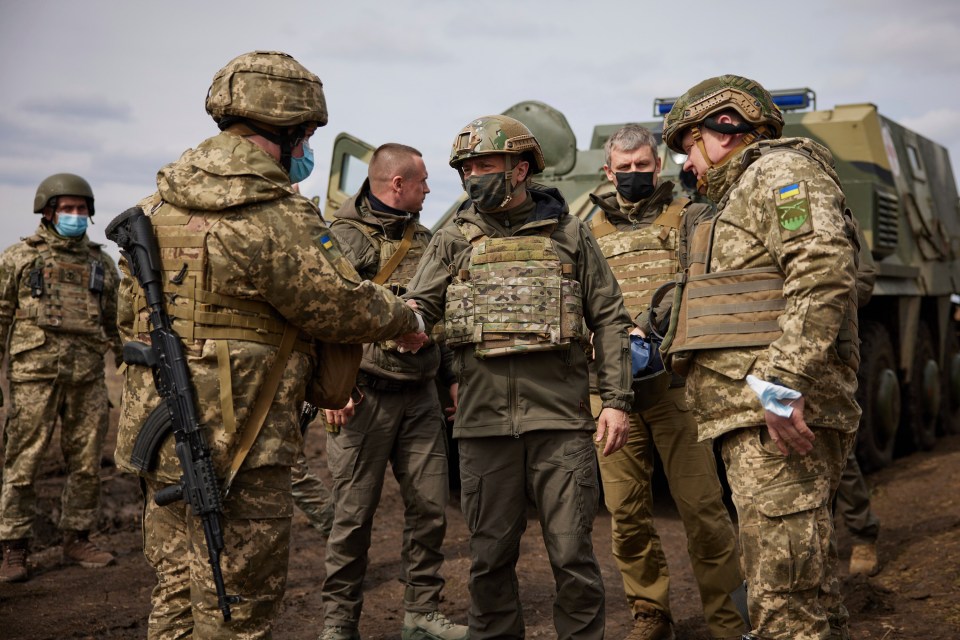 Ukrainian President Volodymyr Zelenskiy shakes hands with a soldier