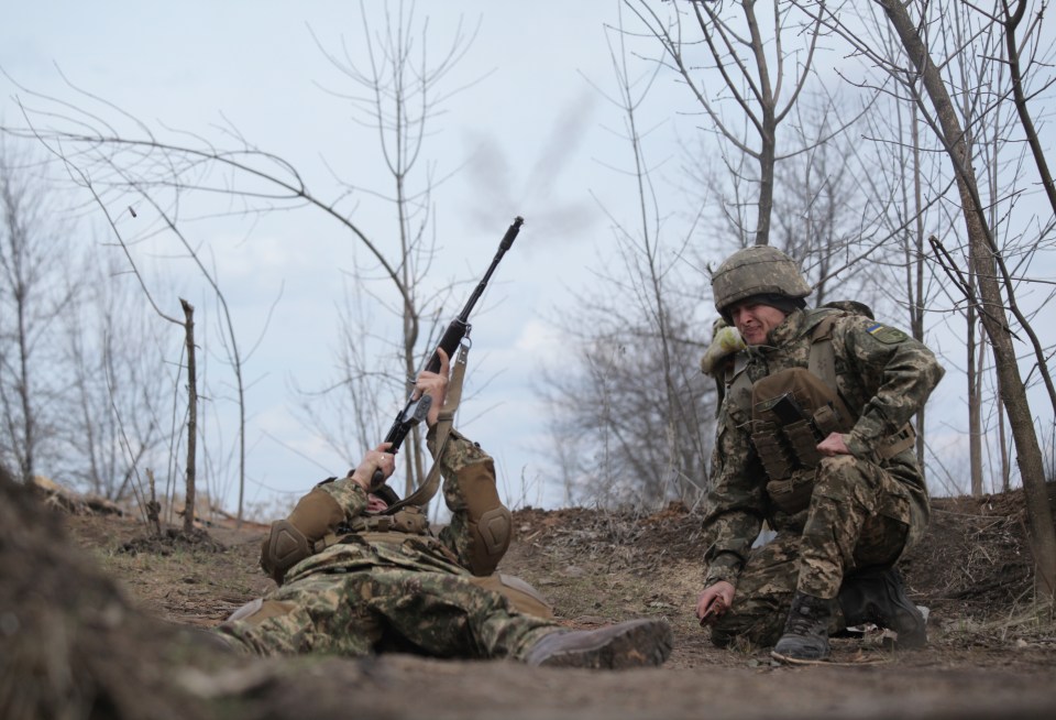 A service member of the Ukrainian armed forces fires in an attempt to shoot down an alleged unmanned aerial vehicle