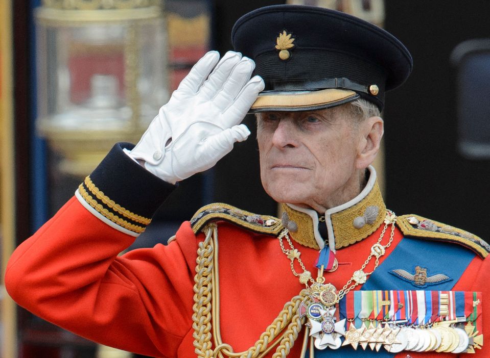 Duke of Edinburgh salutes as he watches the troops ride past outside Buckingham Palace following the Queen's Birthday Parade in 2012