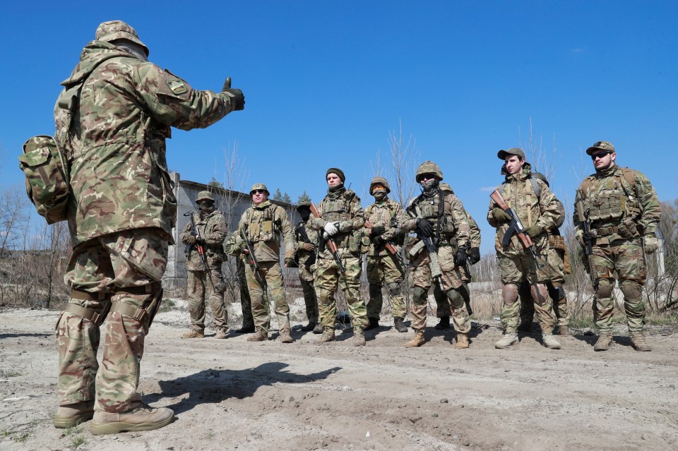 An instructor speaks to reservists of the 130th battalion of the Ukrainian Territorial Defence Forces during military exercises on outskirts of Kyiv