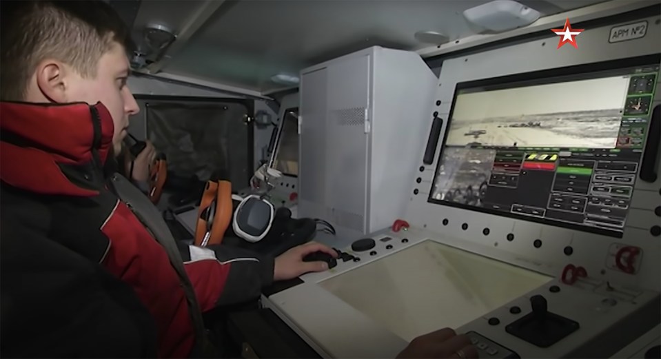 The crew of Uran-9 sit at the controls inside an armoured vehicle