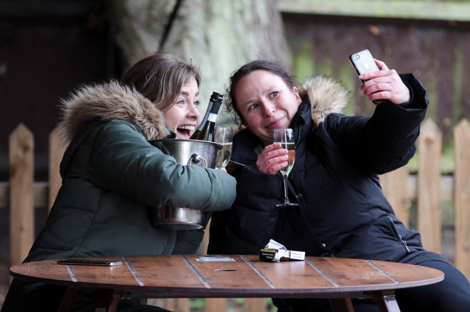 Women take a selfie with their drinks at The Fox on the Hill pub in London