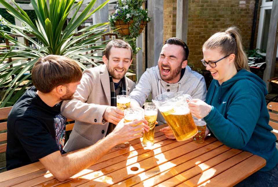 Friends share a pitcher of beer at the Prince Blucher, Twickenham, south west London