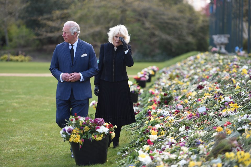 The royal couple looked emotional as they walked past a sea of flowers