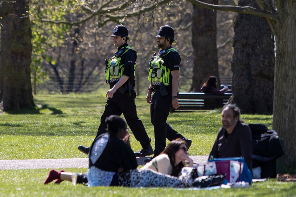 Police patrol as members of the public relax and enjoy the sunny weather in Hyde Park in central London