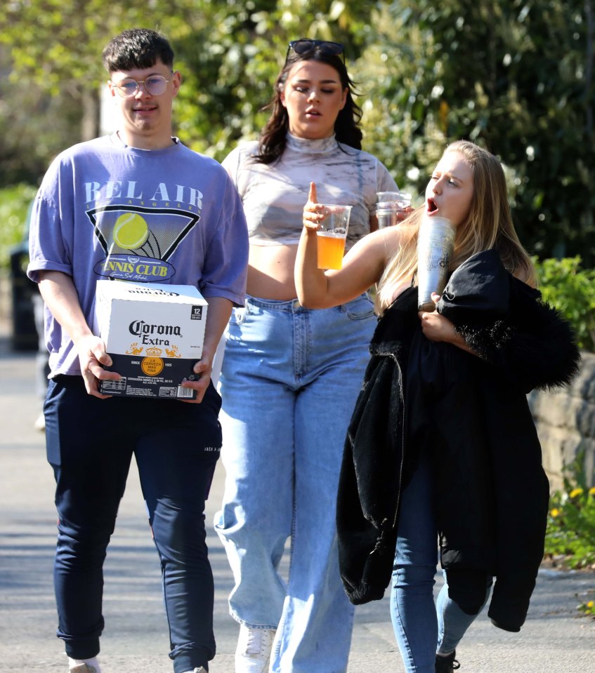 A lad carries a 12 pack of Corona while his pals walk with a drink in hand in Leeds