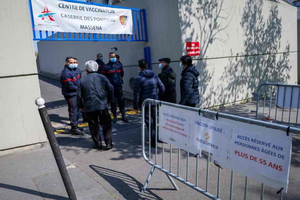 Firefighters stand at the entrance of a Covid-19 vaccination centre set up in a fire station in the 13th arrondissement of Paris