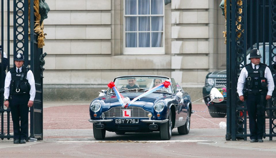 Just married . . . leaving the Buckingham Palace reception in Prince Charles’s Aston Martin